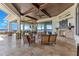 Expansive covered patio with a fireplace and travertine flooring, overlooking the water view at 10845 Bayshore Dr, Windermere, FL 34786