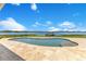 Inviting in-ground pool features travertine tile surround and scenic lake views at 10845 Bayshore Dr, Windermere, FL 34786