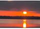 A picturesque view of a vibrant sunset reflecting over the calm lake waters at 10845 Bayshore Dr, Windermere, FL 34786
