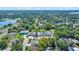 Aerial view of a neighborhood featuring lush greenery and a tranquil lake at 1115 S Mary St, Eustis, FL 32726