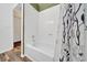 Bathroom showing tub with decorative shower curtain, white tile and neutral paint at 1115 S Mary St, Eustis, FL 32726