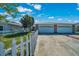 Exterior view of a duplex with garages, white picket fence and landscaping at 1115 S Mary St, Eustis, FL 32726
