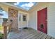 Covered porch with wooden decking, brick accents, and two entry doors at 1115 S Mary St, Eustis, FL 32726
