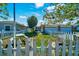 Inviting front yard with a white picket fence, picnic table, mature trees, and well-kept lawn at 1115 S Mary St, Eustis, FL 32726