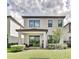 Well-maintained backyard with green grass, a covered patio, and a view of the home's rear facade at 1147 Wildmeadow Run, Winter Park, FL 32792