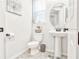 Bright powder room with pedestal sink, neutral tile floors, and oval mirror over the sink at 1147 Wildmeadow Run, Winter Park, FL 32792
