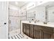 Modern bathroom featuring double sinks, an elegant shower with a glass door, and stylish floor tiling at 1147 Wildmeadow Run, Winter Park, FL 32792