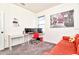 Inviting room with an office desk, a modern red chair, an artsy photo hanging on the wall, and gray carpet flooring at 1147 Wildmeadow Run, Winter Park, FL 32792