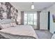 Well-lit bedroom offers floral accent wall, a window view, and plush carpeting for a comfortable space at 1147 Wildmeadow Run, Winter Park, FL 32792