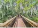 Picturesque wooden boardwalk winding through a serene natural landscape with lush greenery and mature trees at 1147 Wildmeadow Run, Winter Park, FL 32792