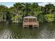 Scenic waterfront property featuring a covered wooden dock perfect for relaxing and enjoying the lake views at 1147 Wildmeadow Run, Winter Park, FL 32792