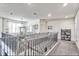 Upstairs hallway with wrought iron railing and neutral carpet, leading to bedrooms and bonus space at 1147 Wildmeadow Run, Winter Park, FL 32792