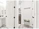 Hallway featuring a view of the laundry room, pedestal sink, and white doors with contrasting hardware at 1147 Wildmeadow Run, Winter Park, FL 32792