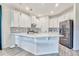 Bright kitchen with white cabinets, quartz countertops, stainless steel appliances, and gray wood-look flooring at 1147 Wildmeadow Run, Winter Park, FL 32792