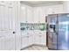 Bright kitchen featuring white cabinets, stainless steel appliances, and mosaic tile backsplash at 1147 Wildmeadow Run, Winter Park, FL 32792