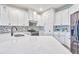 Bright kitchen featuring white cabinetry, speckled backsplash, quartz countertops, and stainless steel appliances at 1147 Wildmeadow Run, Winter Park, FL 32792