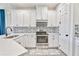 Modern kitchen featuring white cabinets, stainless steel appliances, and decorative tile backsplash at 1147 Wildmeadow Run, Winter Park, FL 32792