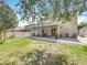 Large backyard featuring a covered patio, lush green grass, and privacy fence at 11868 Thatcher Ave, Orlando, FL 32836