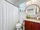 Cozy bathroom featuring a vanity, sink, toilet, shower, and framed round mirror at 11868 Thatcher Ave, Orlando, FL 32836