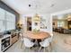 Dining area with a round wooden table, white chairs, and stylish lighting fixture at 11868 Thatcher Ave, Orlando, FL 32836