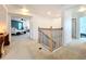 Hallway with carpet and decorative black iron staircase with views into primary bedroom at 11868 Thatcher Ave, Orlando, FL 32836