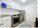 Modern laundry room with a stainless steel washer, dryer, and refrigerator at 11868 Thatcher Ave, Orlando, FL 32836