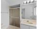 Bathroom featuring a glass enclosed shower, tiled vanity, and a large mirror at 12508 Lake Denise Blvd, Clermont, FL 34711