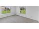 This bedroom has two windows with views of the well-maintained lawn at 12508 Lake Denise Blvd, Clermont, FL 34711