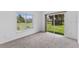 Bright bedroom with plush carpeting, a sliding glass door and a large window overlooking the lawn at 12508 Lake Denise Blvd, Clermont, FL 34711