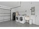 Clean, organized garage featuring epoxy flooring, laundry area, and utility sink at 12508 Lake Denise Blvd, Clermont, FL 34711