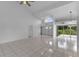 Open living room with tile flooring, high ceilings, and sliding glass doors offering a view of the yard at 12508 Lake Denise Blvd, Clermont, FL 34711