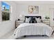 Comfortable bedroom features a large window, striped bedding, and neutral decor at 13791 Abberwick Dr, Orlando, FL 32832