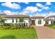 Beautiful single-story home with manicured lawn, lovely landscaping, brick driveway, and tile roof at 13791 Abberwick Dr, Orlando, FL 32832