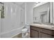 Clean bathroom with shower-tub combo, ample lighting, and a vanity with a dark wood cabinet at 14325 Hidden Ct, Clermont, FL 34711