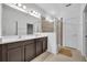 Well-lit bathroom featuring a double sink vanity, glass-enclosed shower, and neutral tile at 14325 Hidden Ct, Clermont, FL 34711