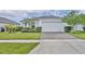 Charming single-story home boasts a well-manicured lawn and a spacious two-car garage at 14325 Hidden Ct, Clermont, FL 34711