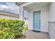 Eye-level front view of home's bright blue entry door surrounded by lush landscaping at 14325 Hidden Ct, Clermont, FL 34711