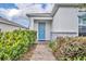 Inviting front entrance features a bright blue door and well-maintained landscaping at 14325 Hidden Ct, Clermont, FL 34711