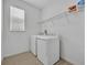 Well-lit laundry room equipped with a washer, dryer, utility sink, and storage shelf at 14325 Hidden Ct, Clermont, FL 34711