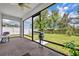 Lovely screened patio with ceiling fan, brick floor, and a peaceful view of the fenced-in yard at 14325 Hidden Ct, Clermont, FL 34711