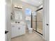 Bright bathroom with white vanity, framed mirror, and glass-enclosed shower featuring a dark trim at 14525 Englert Aly, Orlando, FL 32827
