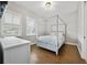 Comfortable bedroom features a bed, hardwood floors, windows with shutters and a desk at 14525 Englert Aly, Orlando, FL 32827