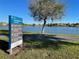 Community information sign near a tranquil lake offering Craft Homes, Dream Finders, Ashton Woods, and David Weekley Homes at 14525 Englert Aly, Orlando, FL 32827