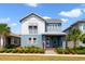 Charming two-story home featuring a landscaped yard, two tone exterior, and inviting front porch at 14525 Englert Aly, Orlando, FL 32827