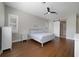 Spacious main bedroom with wood look floors, a ceiling fan, and an ensuite bathroom with a sliding barn door at 14525 Englert Aly, Orlando, FL 32827