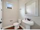 Stylish powder room featuring a pedestal sink, wood look floors, and a window providing natural light at 14525 Englert Aly, Orlando, FL 32827