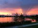 Spectacular sunset over the lake, with vibrant pink and purple hues illuminating the sky and reflecting on the water at 14525 Englert Aly, Orlando, FL 32827