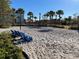 Scenic sand volleyball court with blue lounge chairs, perfect for recreational fun in a tropical setting at 14525 Englert Aly, Orlando, FL 32827