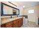 Bathroom featuring a double vanity with granite countertops, large mirror, and updated fixtures at 1470 Winston Rd, Maitland, FL 32751