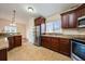 Well-lit kitchen with granite countertops, stainless steel appliances, and dark wood cabinets at 1470 Winston Rd, Maitland, FL 32751